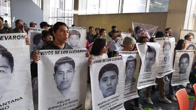 Family members hold posters with the faces of the forcibly disappeared students from Ayotzinapa teachers’ college (Wotancito, Wikimedia Commons / CC BY-SA 4.0) 