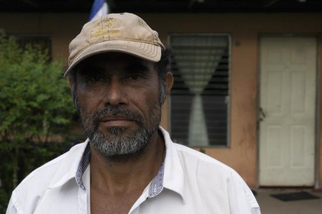 Community forest ranger José Velásquez photographed at Greytown’s pier as he opens documents outlining the rights of Indigenous and Afrodescendant peoples over lands in the southern Atlantic Coast of Nicaragua, November 26, 2019. (Melissa Vid)