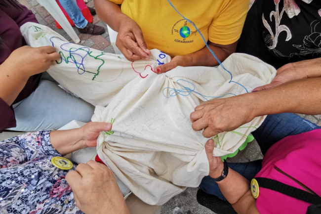 People embroider a memory blanket in Honduras. (Courtesy of Rubén Figueroa)