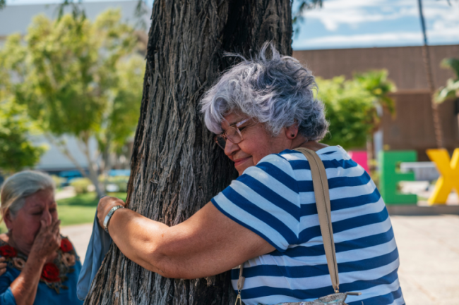 Graciela, who searches for her daughter who is also named Graciela, hugs the Tree of Hope in Mexicali, August 2023. (Sergio Beltrán-García)