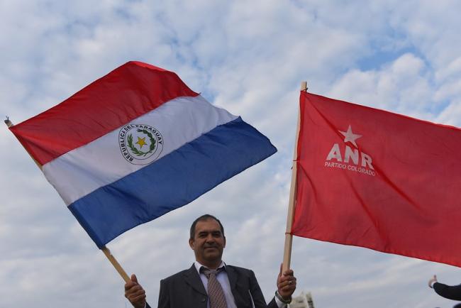 A Paraguayan man holds the Paraguayan national flag and the Colorado party flag. ( Office of the President, Republic of China (Taiwan), Flickr). 
