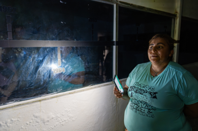 Peace signatory Adriana Villa narrates the timeline at the Manuel Marulanda Museum, shinning her light on the FARC’s year of origin, 1964. Her t-shirt reads: “Women peace signatories for a life in peace and free of violence.” (Alejandro Jaramillo)