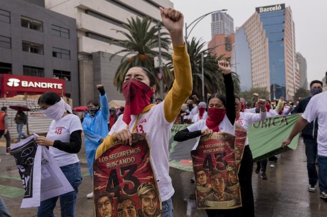 Protesters march through the streets of Mexico City on September 26, 2024, demanding answers for the students who were disappeared 10 years ago. They hold posters that read “We will keep searching for you 43.” (Anita Pouchard Serra)