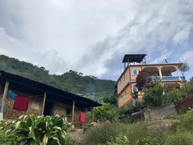 In Ilom, Chajul, Guatemala, an adobe home is seen next to a larger home built with remittances, 2019. (Giovanni Batz)