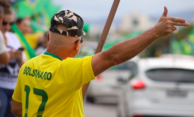 A Bolsonaro supporter makes the president's signature gun gesture. (Michael Fox)