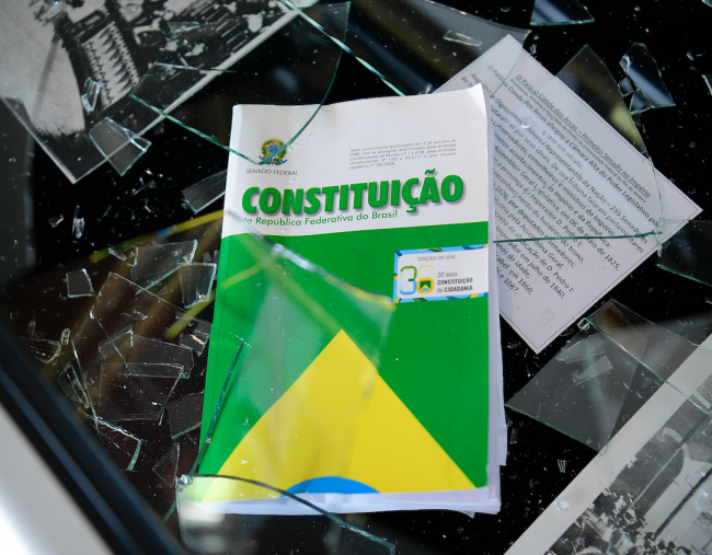 A constituição brasileira está embaixo de um vidro quebrado após a invasão do Congresso Nacional em 8 de janeiro de 2023, em Brasília. (Pedro França / Agência Senado / CC BY 2.0 DEED)