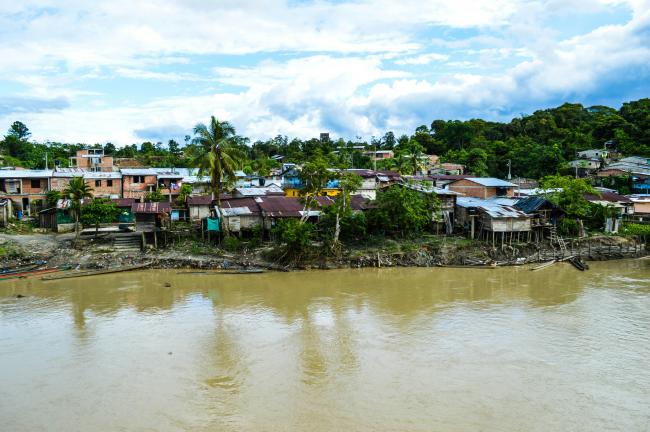 Houses along the river in Puerto Nuevo in Colombia's Chocó department, an area heavily impacted by forced displacement and confinement by criminal groups. (Franklin Peña Gutierrez / Pexels)