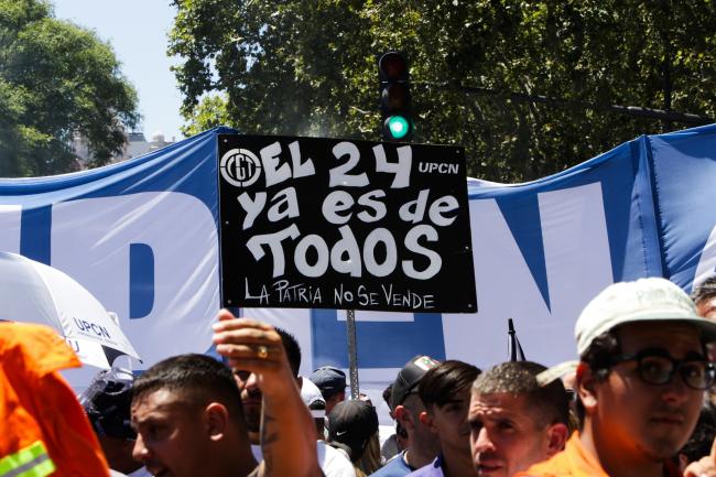 "El 24 ya es de todos. La patria no se vende". El cartel de un manifestante marchando con la Confederación General del Trabajo en el paro nacional del 24 de enero. Buenos Aires. (Susi Maresca)