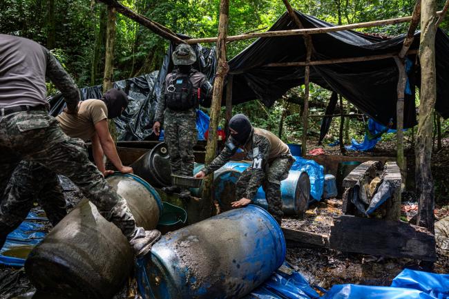 Hondurese soldaten doordrenken een cocaverwerkingslaboratorium met benzine om het in brand te steken. (Fritz Pinnow)