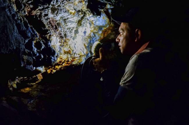 An artisanal miner inspects a gold vein in tunnels deep within Briceño’s hillsides. (Photo by Alex Diamond)
