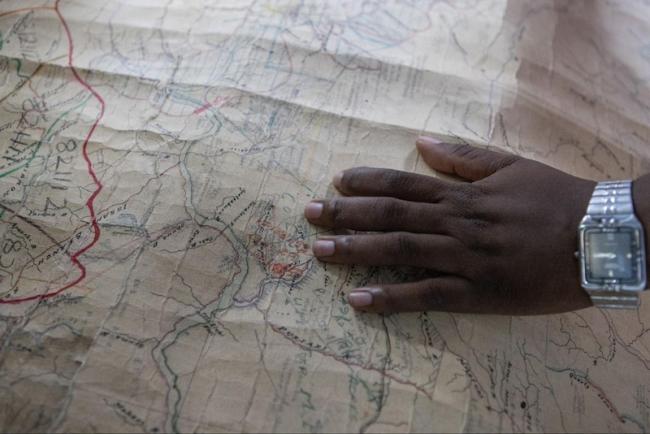 An employee of the Maps Department looks over old maps of the Kako Village region in search of data from the beginning of the last century on Indigenous occupation in the region. (Rafael Vilela / Agência Pública)