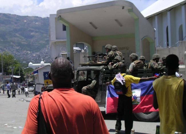 Haitian people defending their flag against U.S. military occupiers following the U.S.-led ouster of President Jean-Bertrand Aristide in 2004. (Mark Schuller)