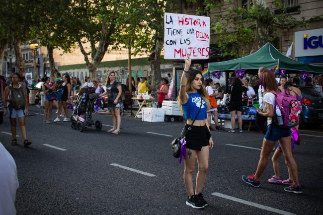 Una huelguista agarra un cartel que dice "la historia tiene una deuda con las mujeres" (Virginia Tognola)