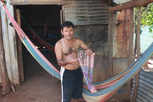 José Eduardo Velázquez Machado crafts a hammock outside his house near El Cuco beach. (Julián Reingold)