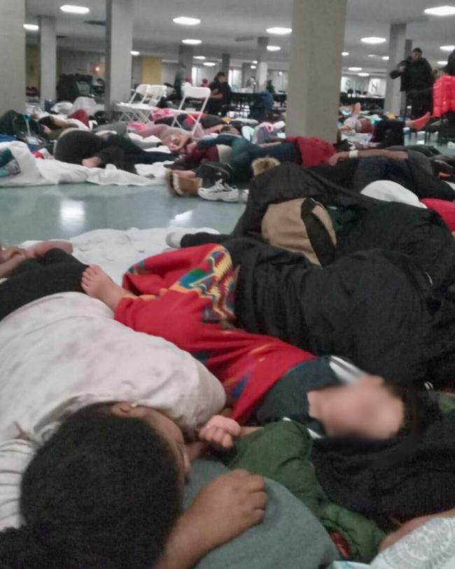 Families sleep on the floor at James Madison High School after an emergency evacuation from the Floyd Bennett shelter due to severe weather conditions. (Image courtesy of a P.S. 315 parent)