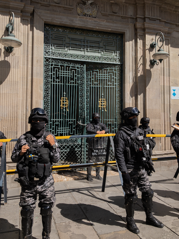 Police guard the damaged doors of Palacio Quemado on Thursday. (Benjamin Swift)