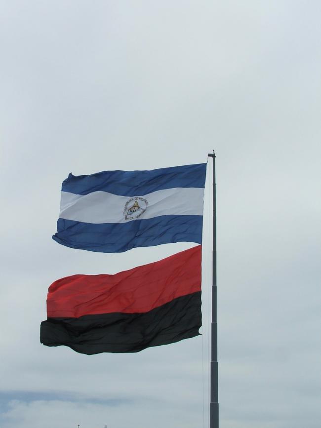 A photograph of the Nicaraguan flag (above) and the Sandinista flag (below). 2004. (Taylor Shelton / Wikimedia Commons / CC BY-SA 2.0)