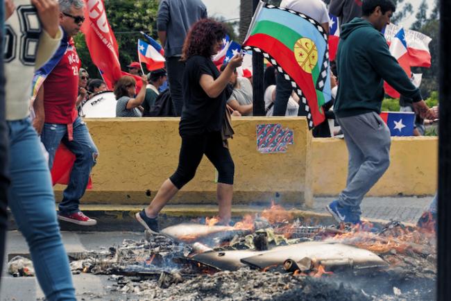 A demonstrator carries the Mapuche flag in a march in San Antonio, Chile, on November 12, 2019. (Photo by Vivian Morales/Flickr)