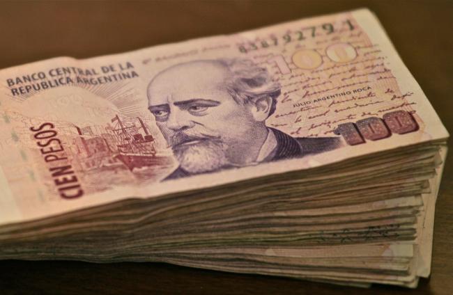A stack of 100-peso bills. Argentina has an annual inflation rate of over 120% as of Oct 2023. The challenge of living in constant economic crisis is on the minds of voters as they decide who to support in the November runoff. (Alex Proimos / Flickr)