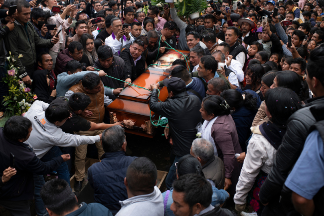 Brothers and family members lower Father Marcelo Pérez's coffin, adorned with an image of Jesus Christ, surrounded by over 3,000 people who came to say goodbye to the priest, October 22, 2024. (Encarni Pindado)