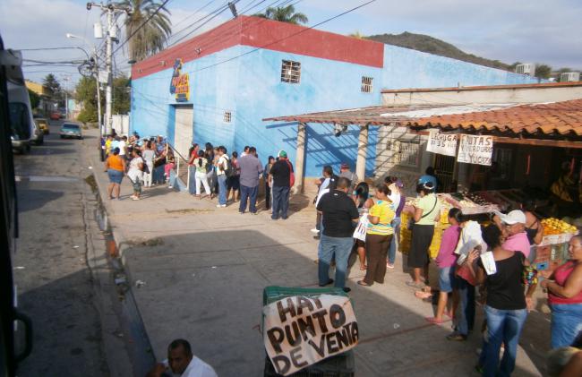 Venezuelans wait in line at a state-run supermarket in 2014  (Wikimedia Commons)
