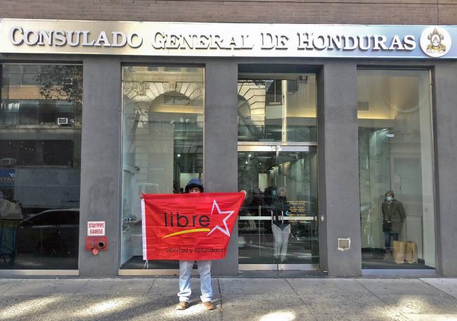 Victor holds a flag in front of the New York City consulate. He plans to fly to Honduras to vote this weekend. (Dashiell Allen)