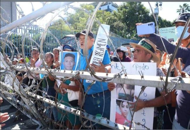 Photos of protestors denouncing the arbitrary detention and disappearance of their family members outside of a Salvadoran prison. (“Santiago”)