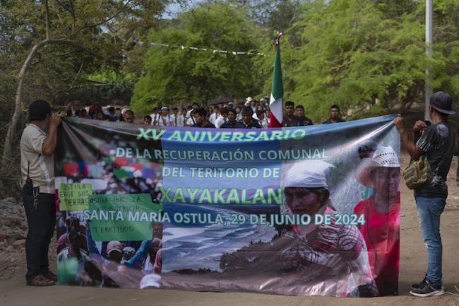 Community members hold up a sign commemorating the 15th anniversary celebration of Xayakalan. (Santiago Navarro F)