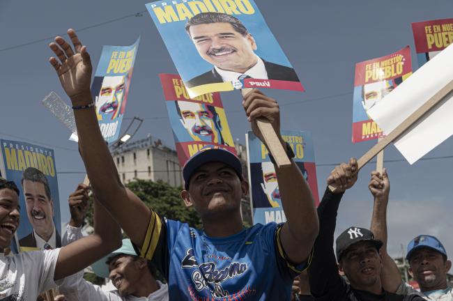 Young men express their support for incumbent President Nicolás Maduro at the closing campaign rally in Caracas on July 25, 2024. (Marcelo Pérez del Carpio)