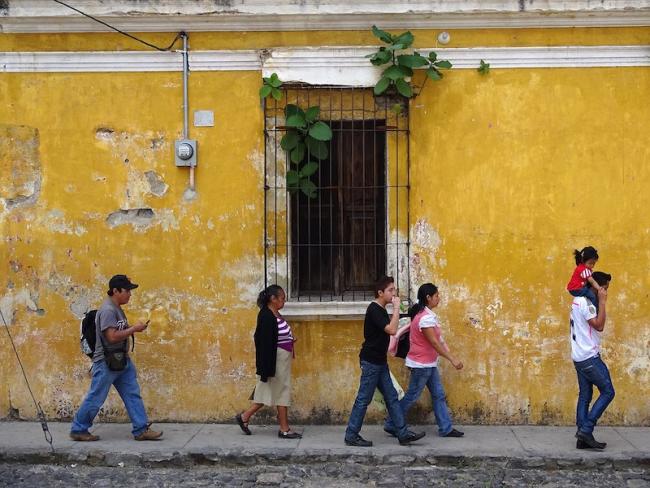 Pedestrians walk on the street in Antigua, Guatemala. (Adam Jones/Wikimedia)