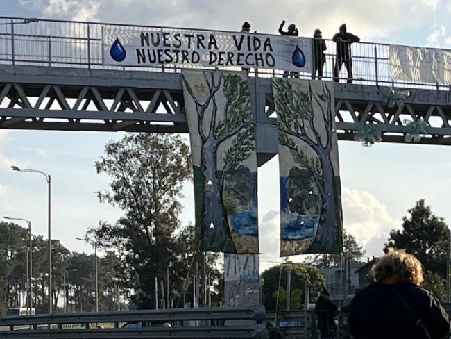 Water access protestors in Uruguay hold up a sign on a bridge reading, "Nuestra vida Nuestro Derecho" (Our life our right). (Grace Livingstone)