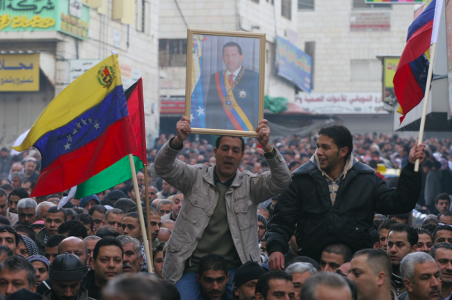 Se levantan la bandera de Venezuela y una foto de Hugo Chávez en una manifestación en Ramallah, Palestina, 2009. (Issam Rimawi)