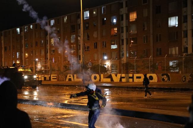 A protester throws a tear gas canister back at police in southern Bogotá, May 10, 2021. (Christina Noriega)