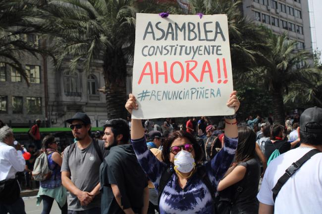 “Constitutional assembly now!! #ResignPiñera,” reads a sign during protests in Chile in October 2019. (José Miguel Cordero Carvacho / Wikimedia)