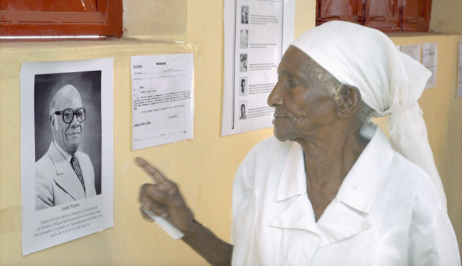 Zeïla Madombé à la commémoration du 20 février 2016, montrant une photo du député André Simon qui a dirigé le massacre de sa famille (Photo de Dominique Franck Simon).