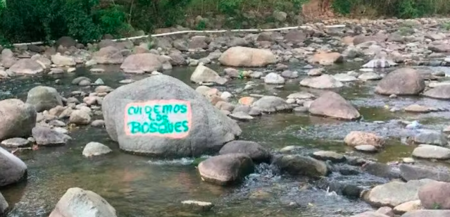 Environmental defenders painted a message in defense of forests on a rock along the Guapinol River (ACAFREMIN)