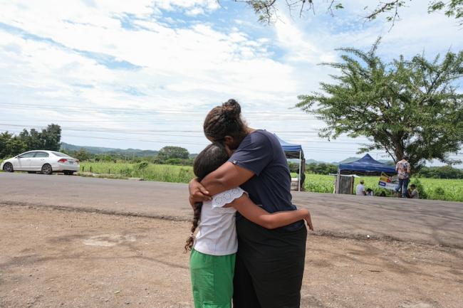 Daisy Cortés hugs her nine-year-old daughter, Daphne, both from Varinas, Venezuala, outside a humanitarian attention center in El Paraíso, Honduras. As of publication, the pair are in southern Mexico awaiting a U.S. asylum appointment. (Timothy O'Farrell)