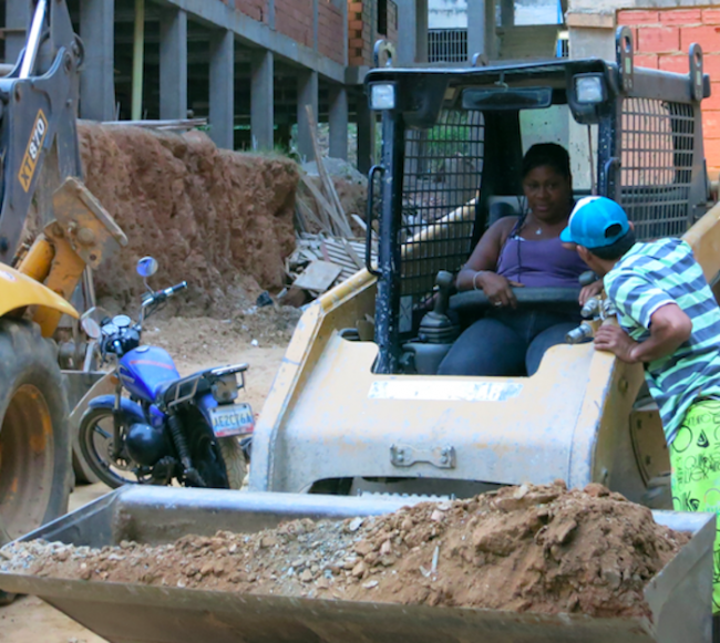 María operates machinery to remove soil and rubble from the construction site at Kaika Shi, 2013. (Andreina Torres Angarita)