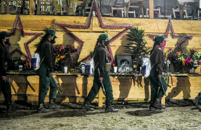 Zapatista women militants walk in formation past the stage and altars to deceased activists at the Zapatistas' 30th anniversary celebrations. (Alejandro Meléndez Ortiz)