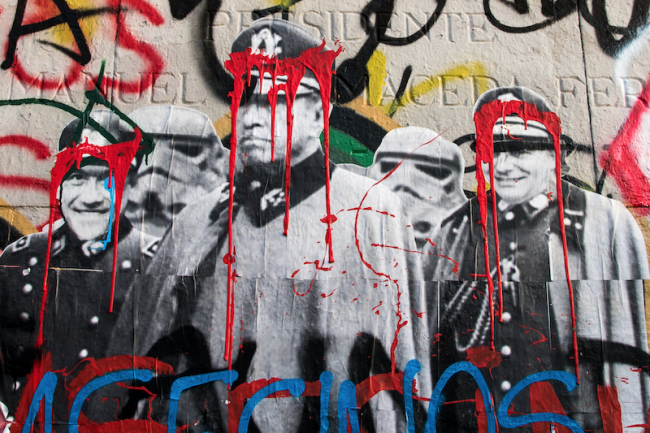 Graffiti in Santiago shows red paint dripping over the images of General Augusto Pinochet and President Sebastián Piñera, November 4, 2019. (Paulo Slachevsky / CC BY-NC-SA)