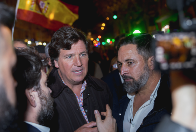 Tucker Carlson y el presidente de Vox, Santiago Abascal, asisten a una protesta contra un plan para otorgar amnistía a separatistas catalanes, en Madrid, el 13 de noviembre de 2023. (VOX ESPAÑA / CC0)