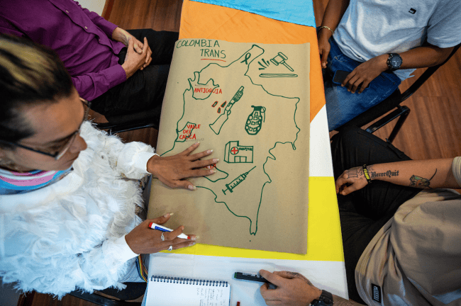 Danna Cuellar, a former FARC militant, draws a map with symbols from the armed conflict as part of a workshop at the two-day event. (Antonio Cascio)